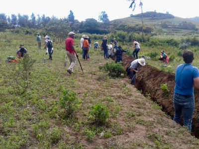 East African farmers and North American students working on a contour in Tanzania